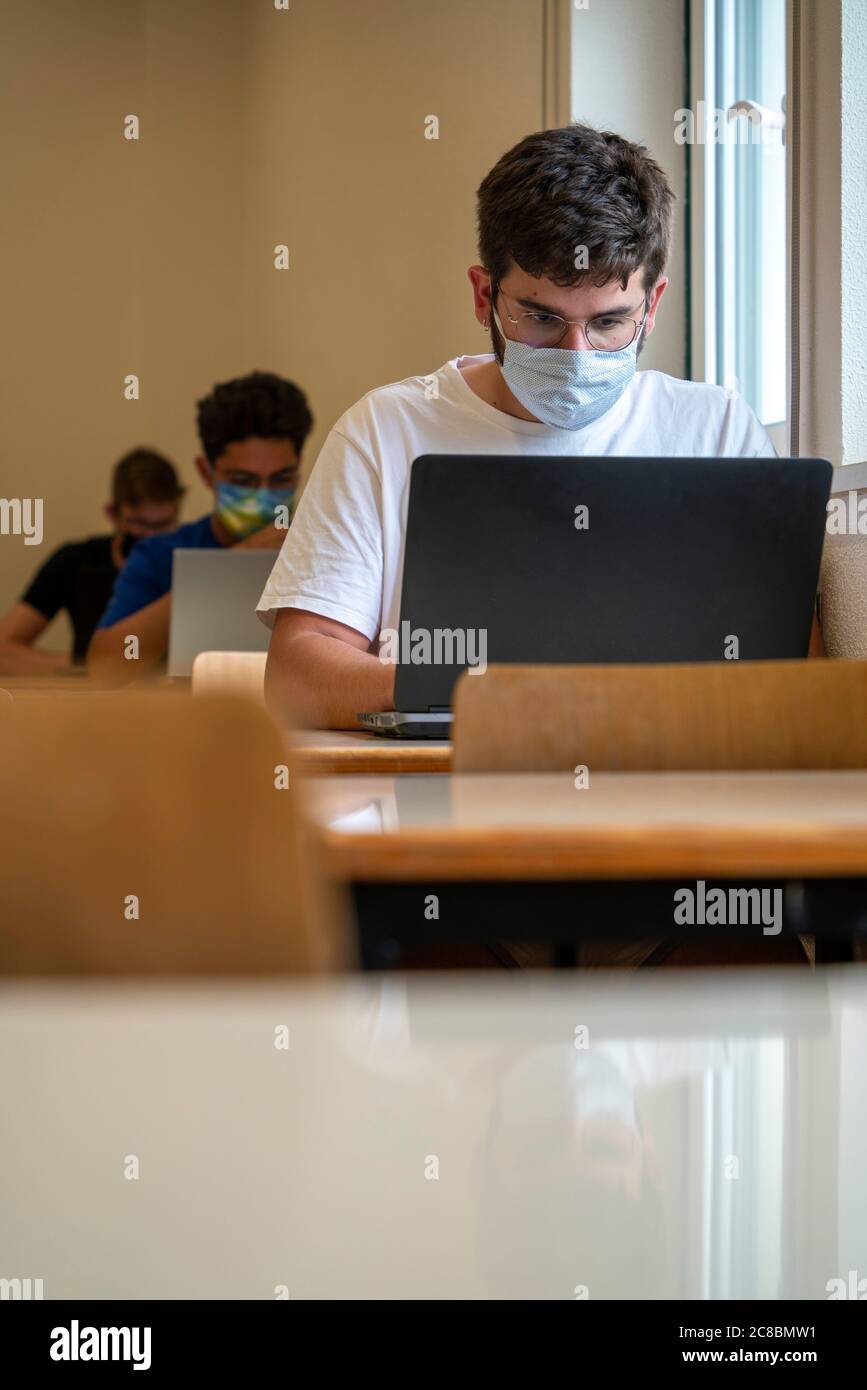 Les élèves portant des masques faciaux en classe pendant la nouvelle pandémie de coronavirus COVID-19 Banque D'Images