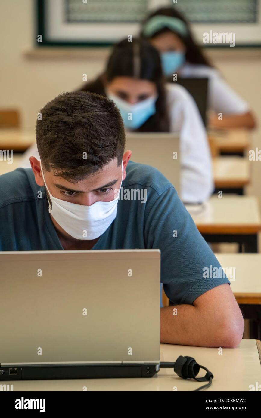 Les élèves portant des masques faciaux en classe pendant la nouvelle pandémie de coronavirus COVID-19 Banque D'Images