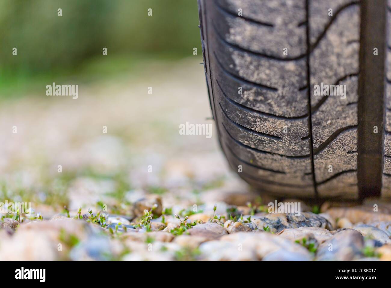 Gros plan de la bande de roulement des pneus de voiture sur la route par temps lumineux Banque D'Images
