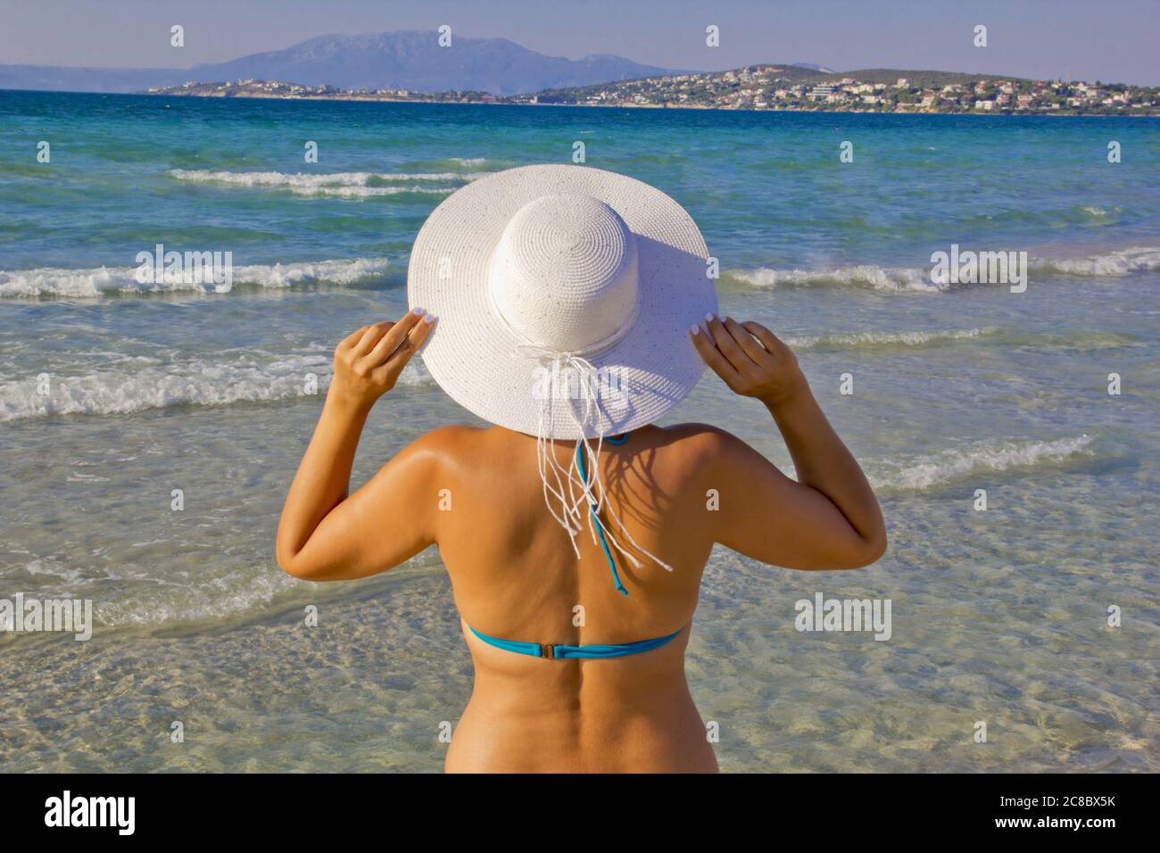 jeune femme en bikini un chapeau blanc sur la plage Banque D'Images