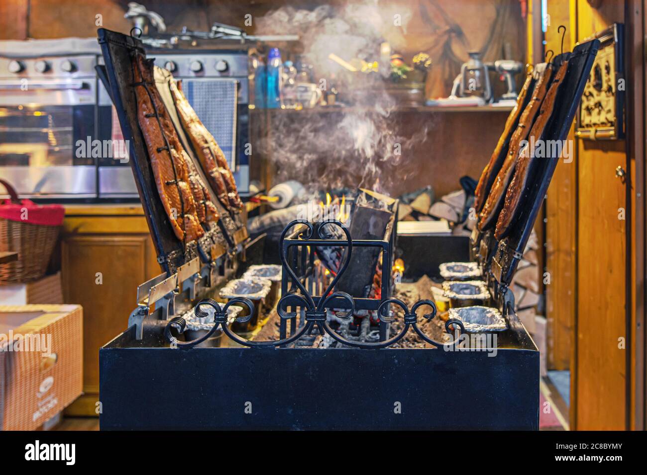 Marché de Noël, Berlin, Allemagne - 9 décembre 2019 : Grill du poisson fumé sur un grand hangar à tabac. À vendre comme marché de la nourriture de rue. Banque D'Images