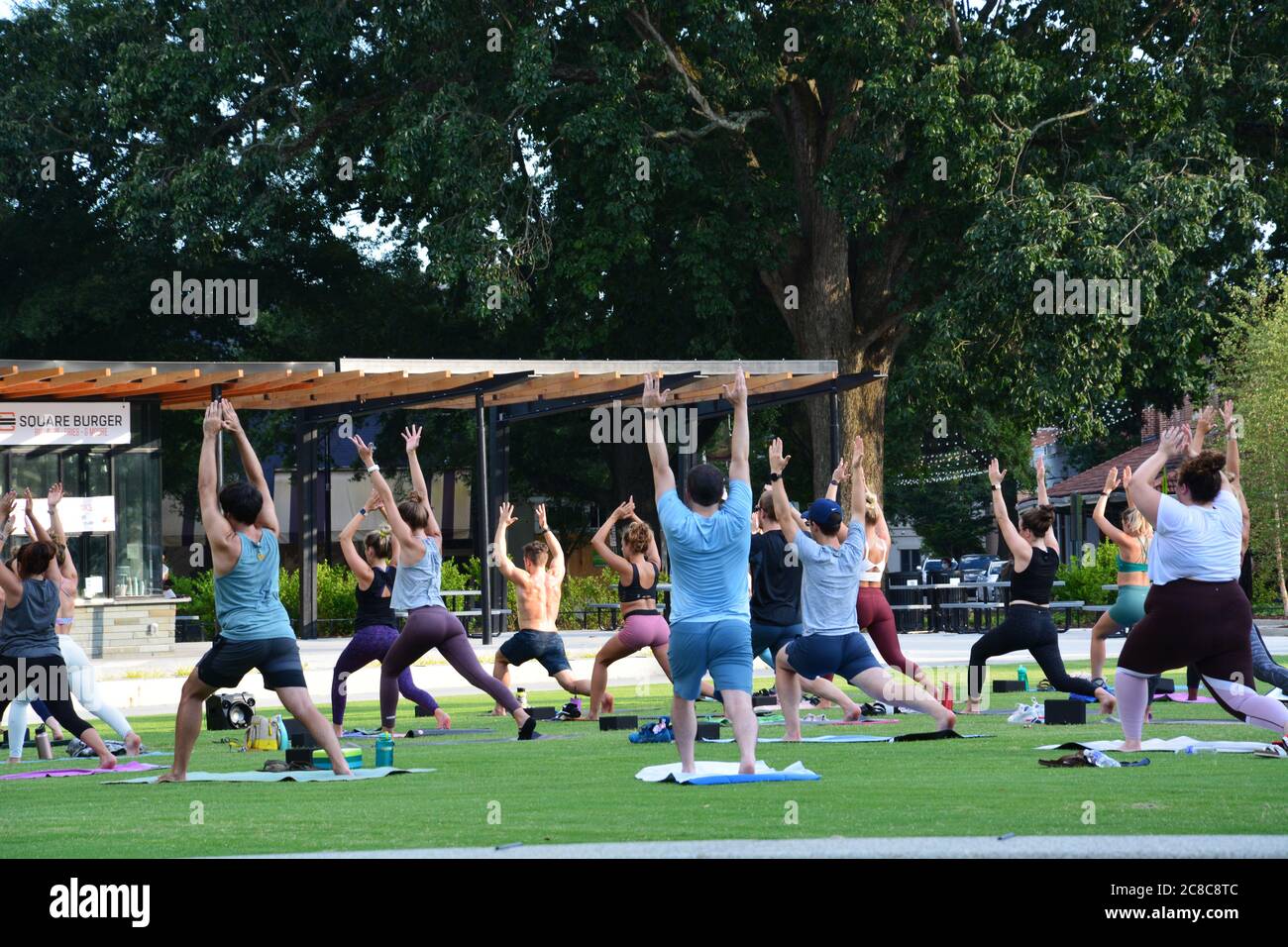 Un studio de yoga emmène ses clients à l'extérieur du parc en raison de la fermeture de la salle de gym à Raleigh, NC liée à la pandémie du coronavirus Covid 19. Banque D'Images