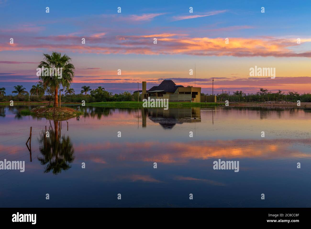 Mariental, Namibie - 26 mars 2019 : lever du soleil au-dessus du luxueux Lapa Lange Game Lodge avec un lac en premier plan situé près de Mariental en Namibie Banque D'Images