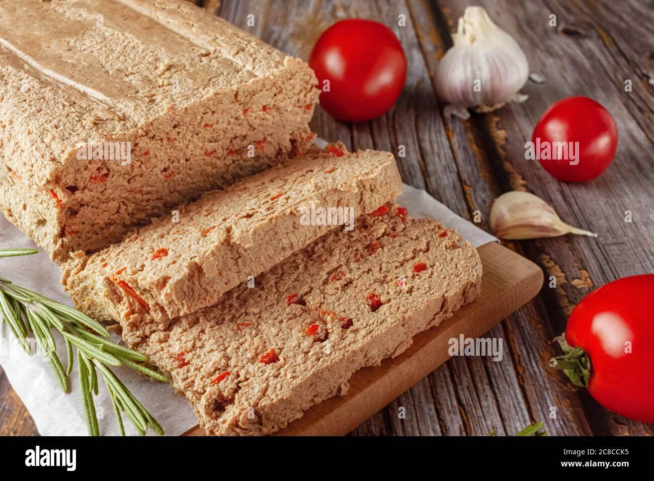 Terrine de poulet fraîche avec légumes et herbes sur une planche à découper en bois Banque D'Images