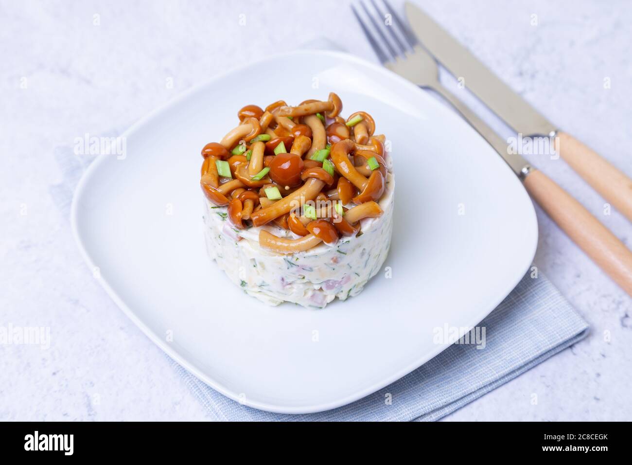 Salade avec champignons (champignon du miel), jambon, pommes de terre, fromage et mayonnaise. Salade russe traditionnelle «panier de champignons». Mise au point sélective, gros plan Banque D'Images