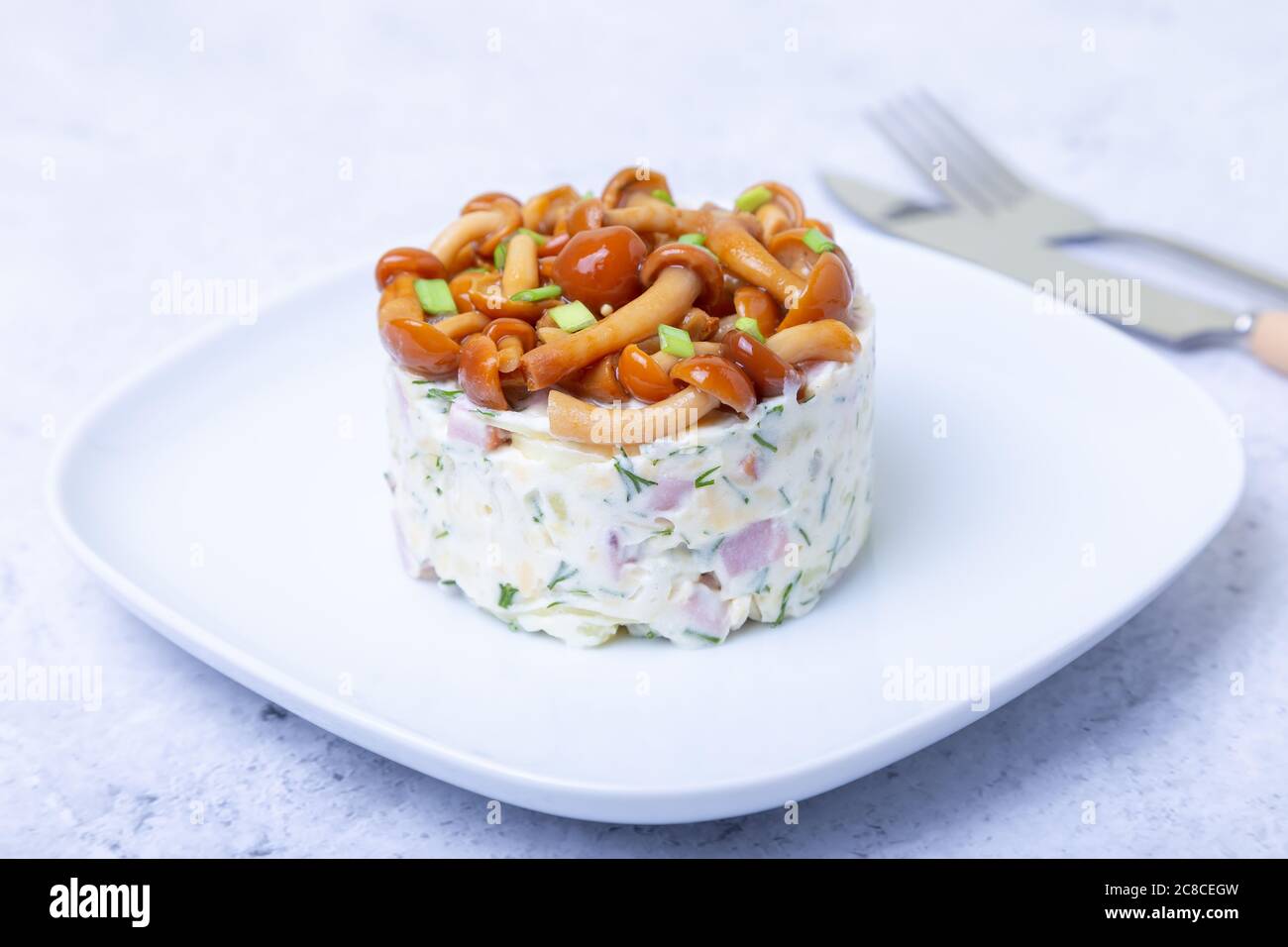 Salade avec champignons (champignon du miel), jambon, pommes de terre, fromage et mayonnaise. Salade russe traditionnelle «panier de champignons». Mise au point sélective, gros plan Banque D'Images