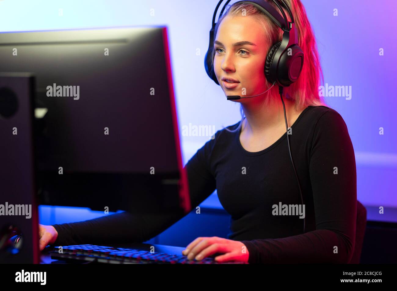 Professionnel E-sport gamer Girl avec casque jouer en ligne jeu vidéo sur PC Banque D'Images