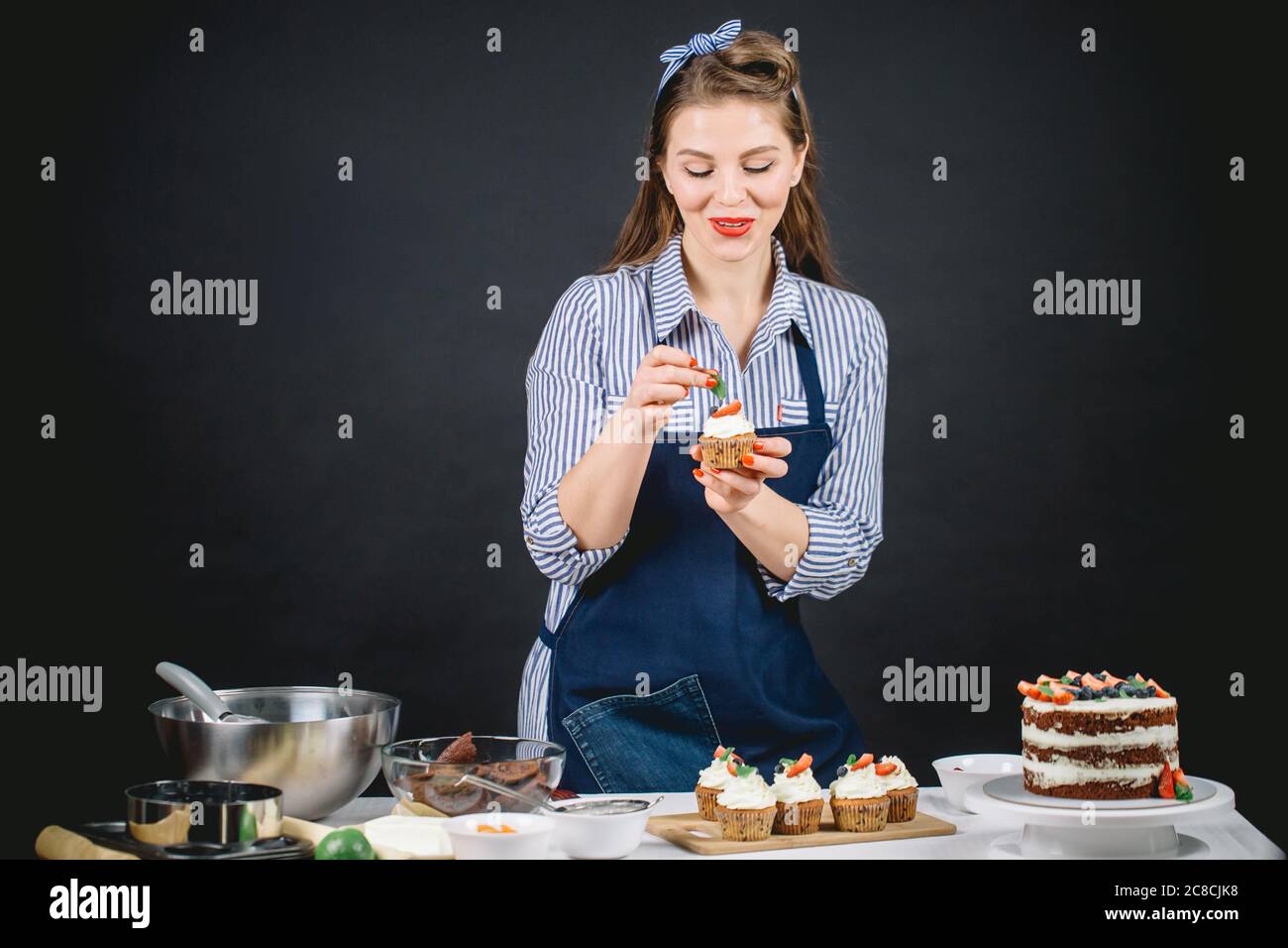 Bonne Jeune Femme Se Preparant Pour La Celebration D Anniversaire Decorant Cremeux Gateau De Garniture Avec Baies Sur Fond Noir Photo Stock Alamy