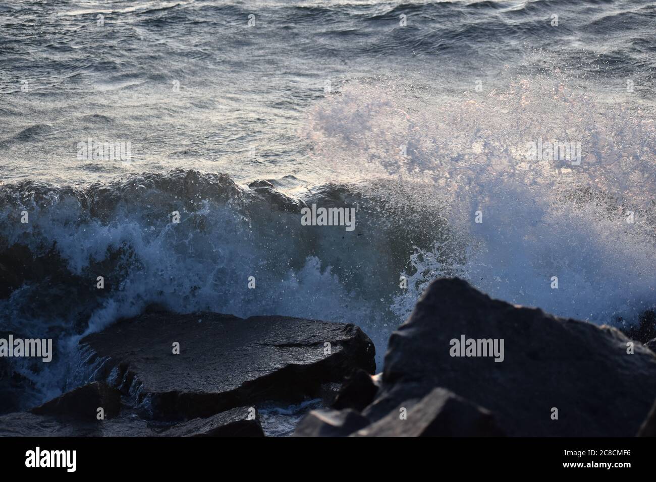 Les vagues déferlent sur les rochers Banque D'Images