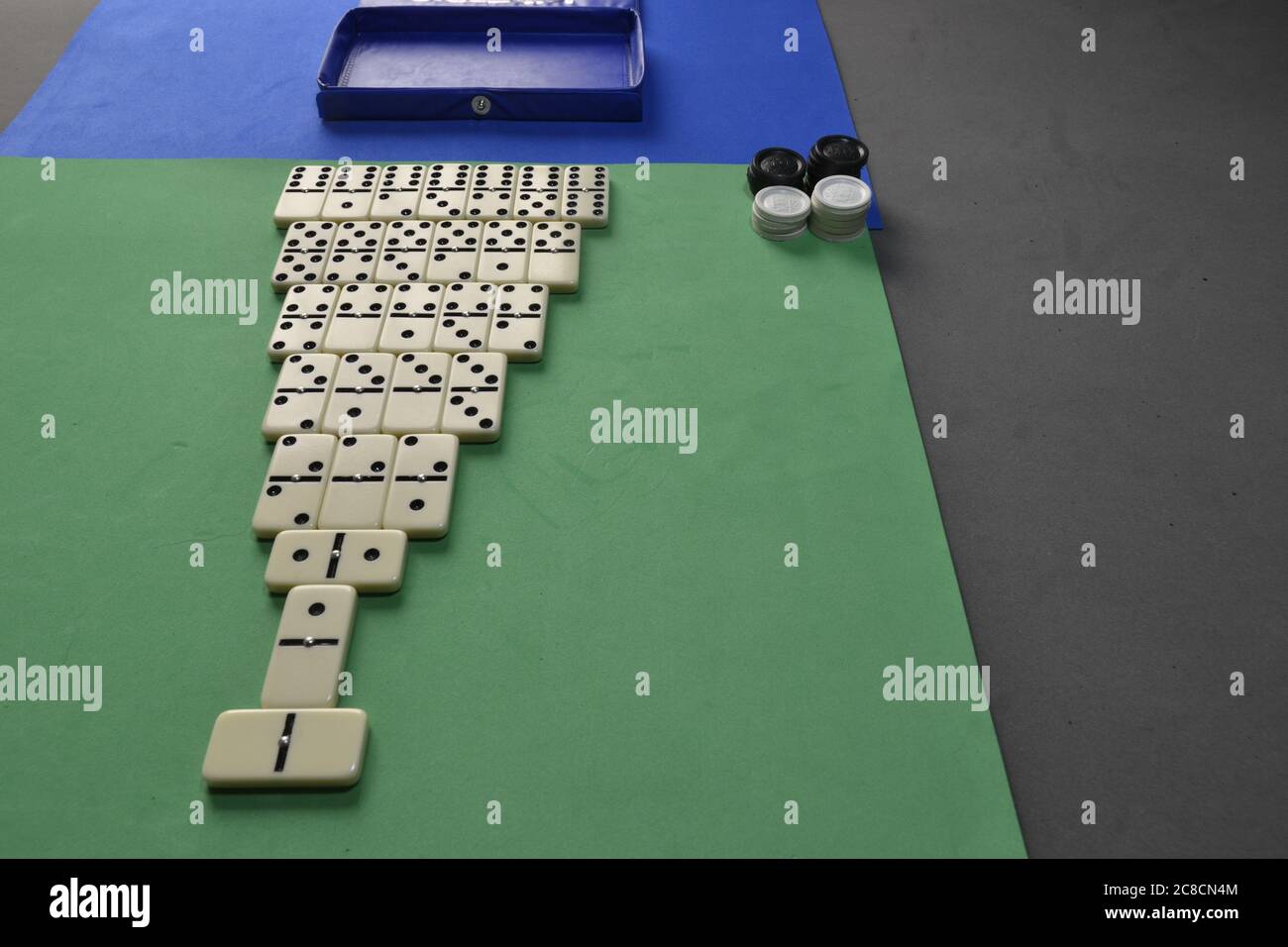 Pyramide verticale de domino avec pierres et jetons sur table verte, bleue et noire, pyramide de Domino et jetons, c'est un jeu de passe-temps, Brésil, Amérique du Sud Banque D'Images