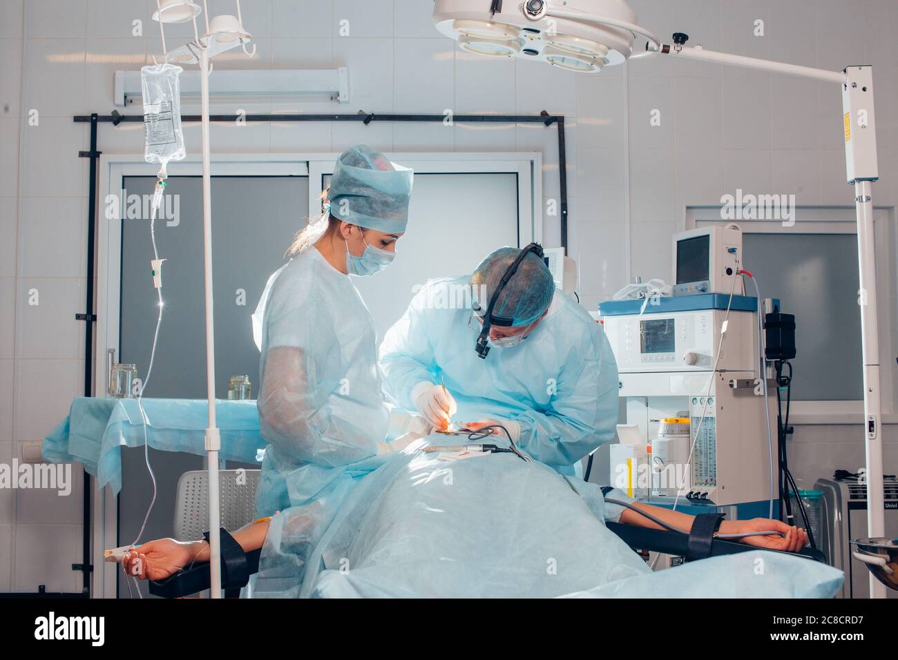 Chirurgien effectuant une chirurgie esthétique du nez dans la salle d'opération de l'hôpital. Chirurgien dans le masque portant des loupes chirurgicales pendant l'intervention médicale. Nez augmenter Banque D'Images