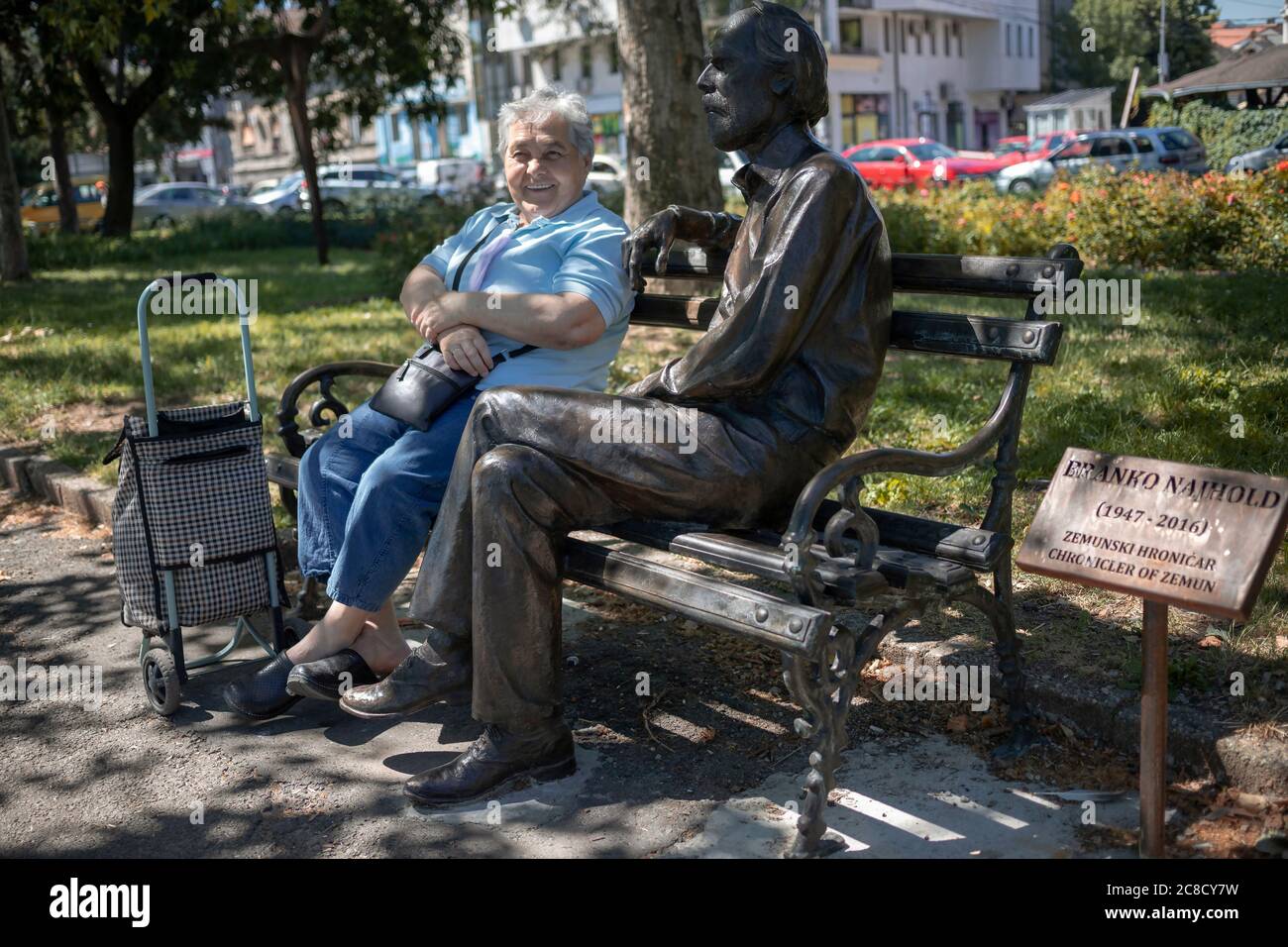 Belgrade, Serbie, 9 juillet 2020 : une femme assise sur un banc à côté d'une statue de bronze Banque D'Images