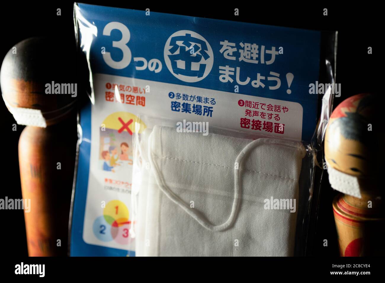 TOKYO, JAPON - 09 mai 2020 : gros plan de deux poupées kokeshi avec un masque facial délivré par le gouvernement japonais, surnommé « masque Abe » pour approvisionner les résidents pendant le temps Banque D'Images