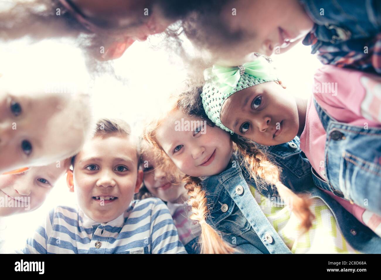 Portrait des enfants heureux formant un caucus au parc. Vue de dessous. Le concept de l'enfance, de l'amitié, de la communication interculturelle. Banque D'Images