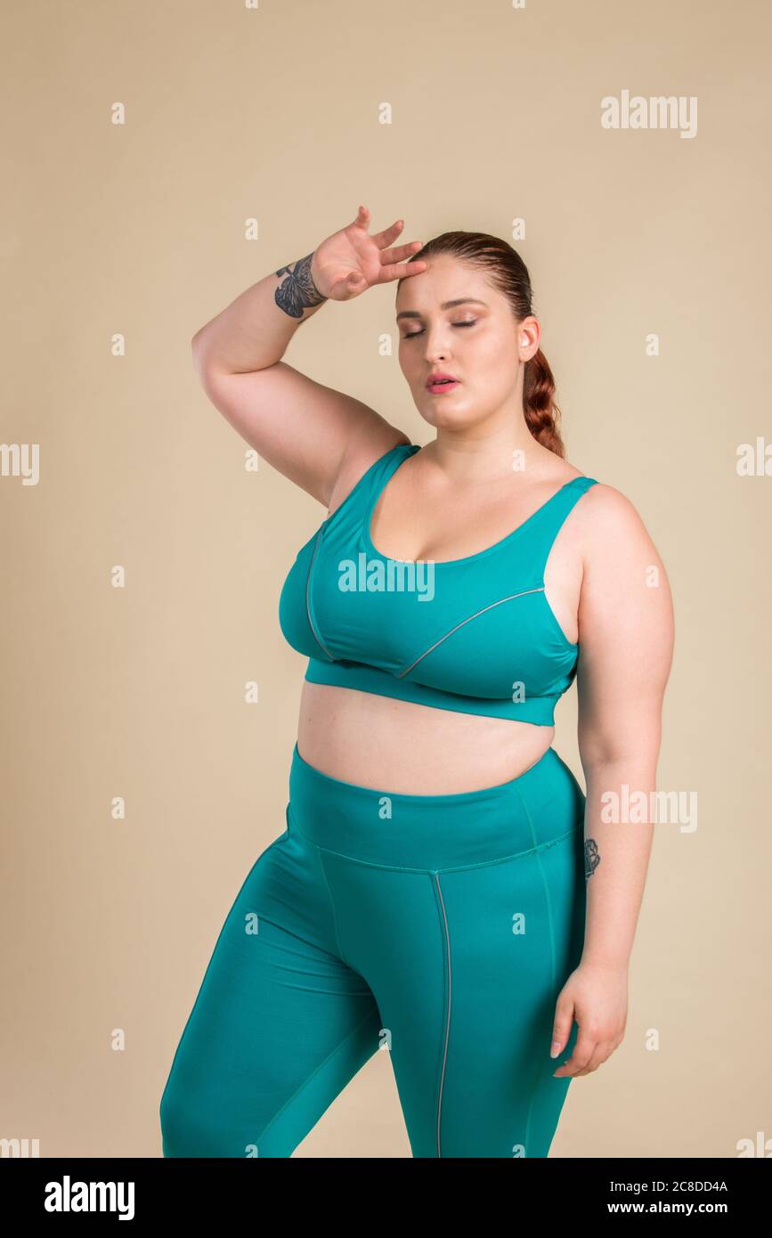 Femme de taille assez grande portant des vetements de sport posant en studio belle fille acceptant l imperfection du corps des photos de beaute en studio concepts sur le corps a