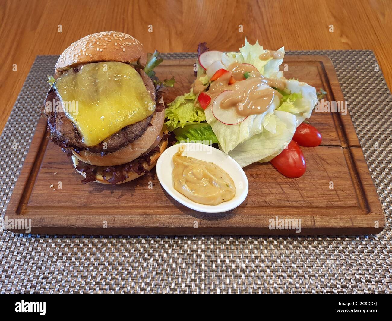 Cheeseburger double servi sur une assiette en bois au restaurant Banque D'Images