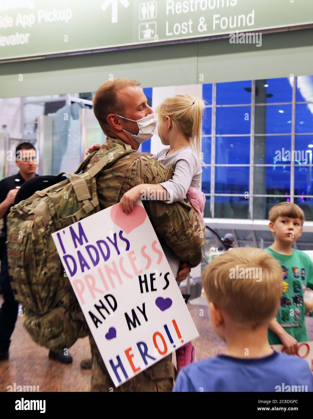 MSGT. Bryce Weight, un garde-bras de l'Alaska du 176e Escadron des forces de sécurité, tient sa fille avec son panneau de bienvenue en main, à l'aéroport international Ted Stevens-Anchorage à son retour de Kandahar, en Afghanistan, le 22 juin 2020. 12 des aviateurs AKNG ont été déployés à l'appui de l'opération Freedom Sentinel, une poursuite de la guerre mondiale contre le terrorisme menée par l'OTAN. (ÉTATS-UNIS Photo de la Garde nationale aérienne par le lieutenant-colonel Candis Olmstead/publié) Banque D'Images