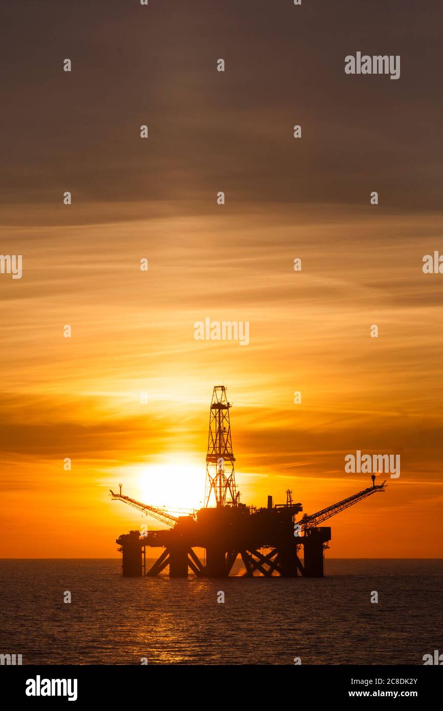 Forage pétrolier à l'heure du coucher du soleil Banque D'Images