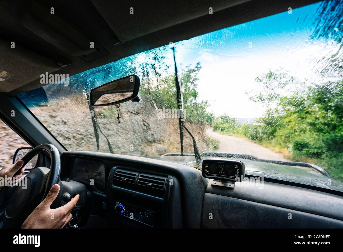 Mains d'un homme sur le volant pendant un trajet sur route Banque D'Images