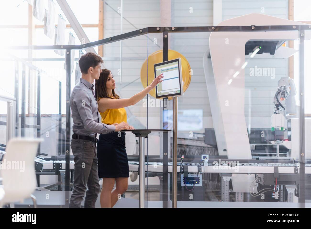 Les gens d'affaires discutent par ordinateur lorsqu'ils sont en usine Banque D'Images