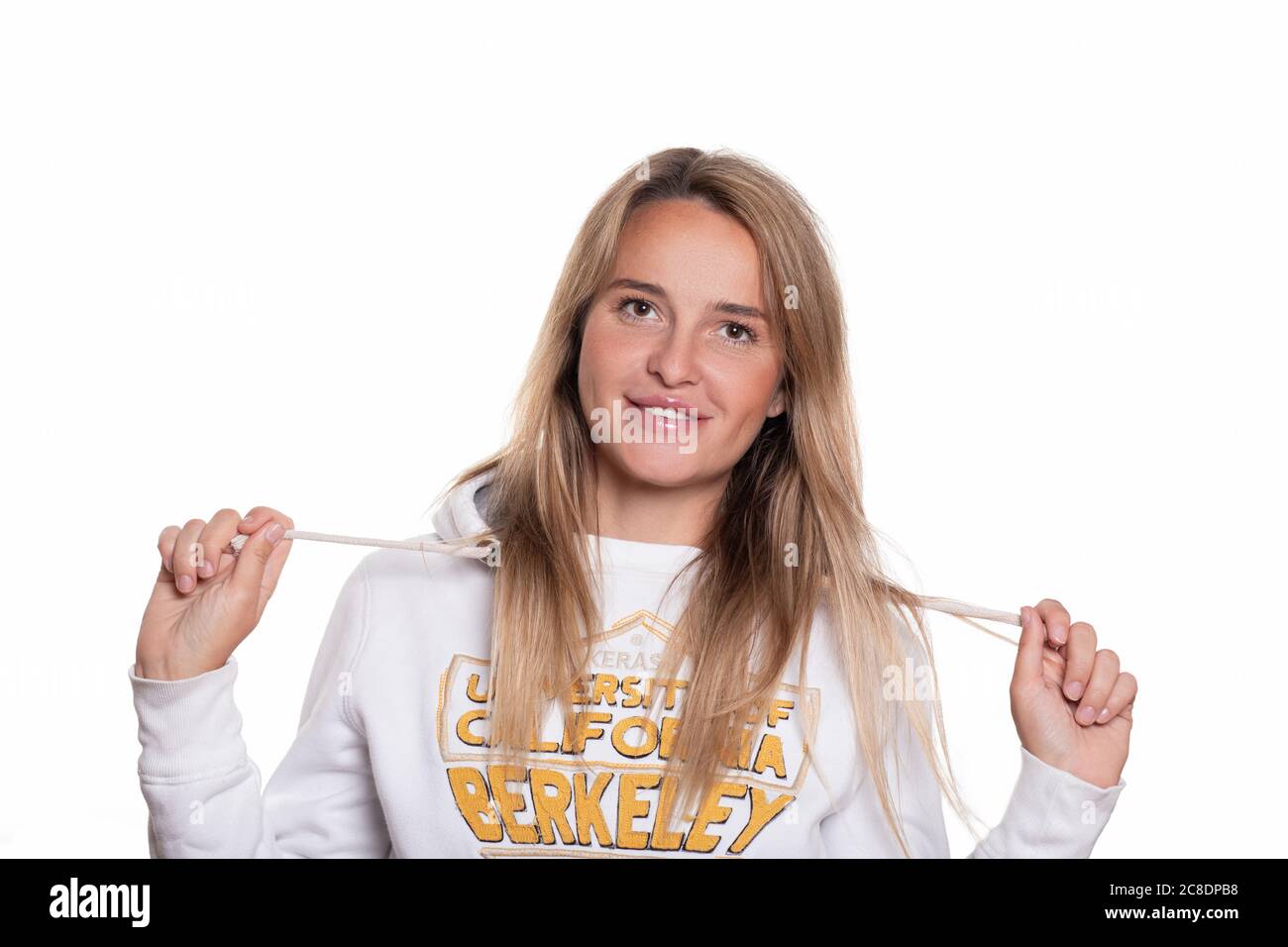 Blonde belle fille avec de longs cheveux dans un sweat-shirt sur un fond blanc sourit et regarde dans l'appareil photo. Prise de vue horizontale isolée, portrait d'un 30 Banque D'Images