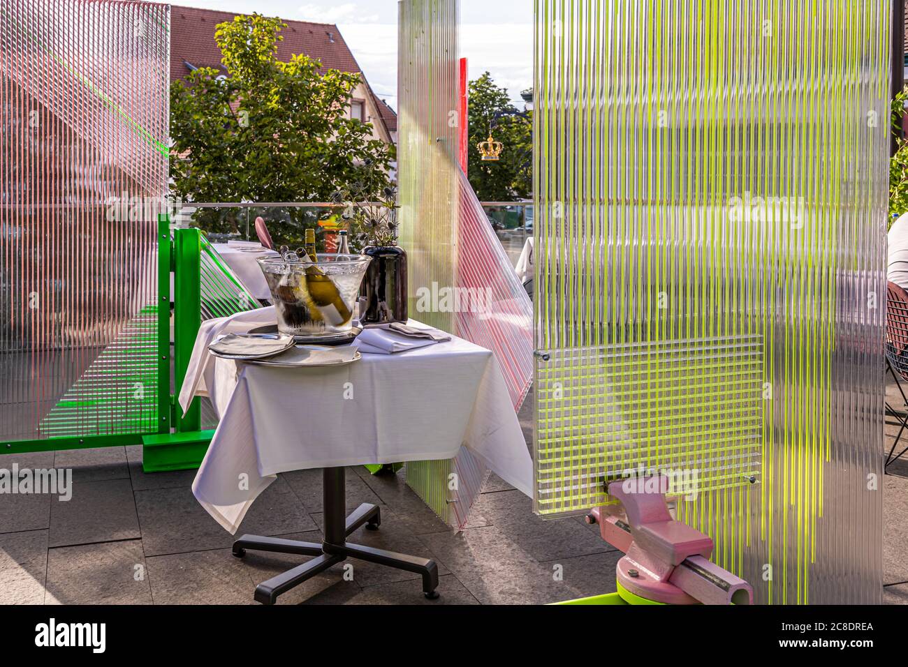 Restauration extérieure avec cloisons artistiquement conçues et serveurs avec masques de protection à l'Hôtel Krone à Weil am Rhein, Allemagne Banque D'Images