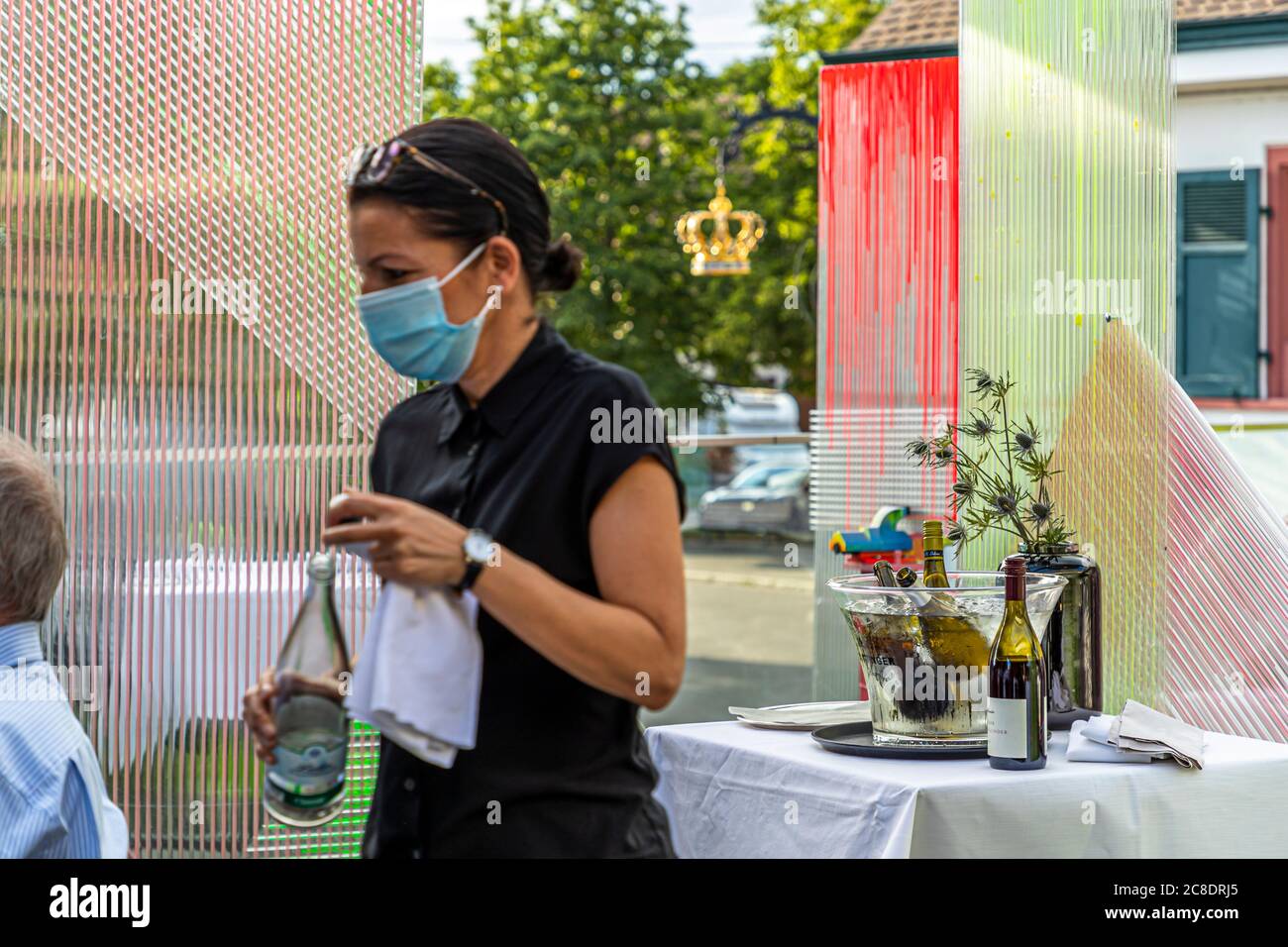 Restauration extérieure avec cloisons artistiquement conçues et serveurs avec masques de protection à l'Hôtel Krone à Weil am Rhein, Allemagne Banque D'Images