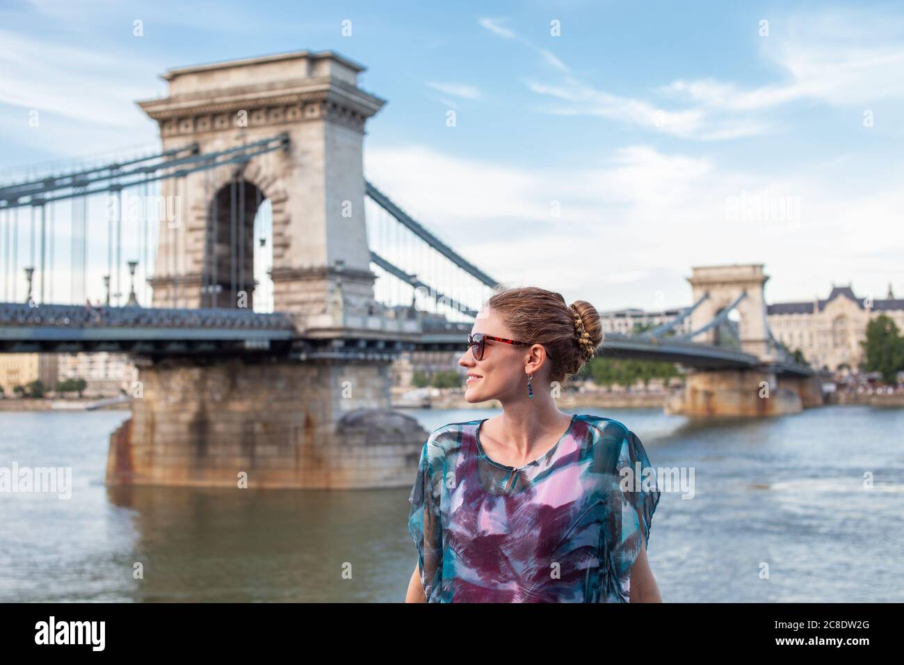 Bonne jeune femme voyageur regardant loin à Chain Bridge, Budapest, Hongrie Banque D'Images
