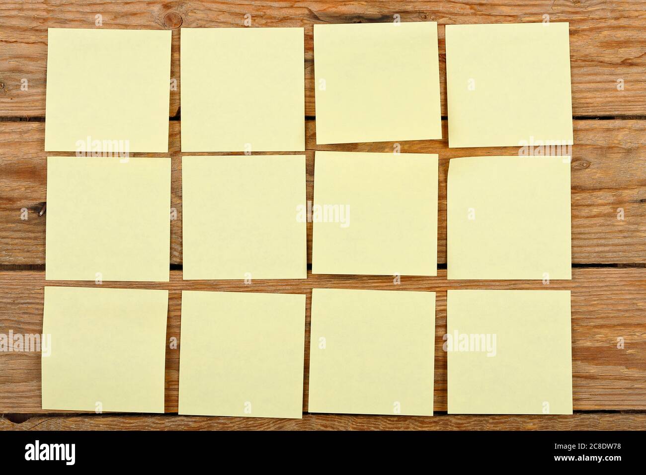douze notes jaunes sur des planches en bois Banque D'Images