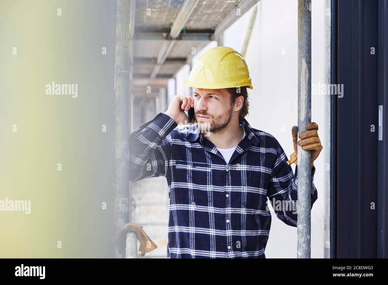 Travailleur au téléphone un chantier de construction Banque D'Images