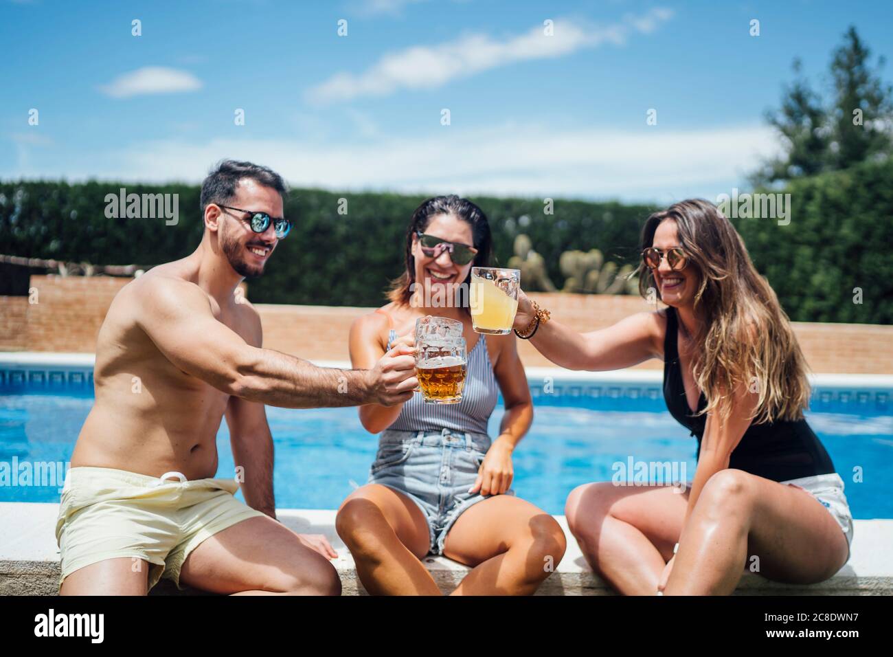 Amis pendant la fête de la piscine avec de la bière Banque D'Images