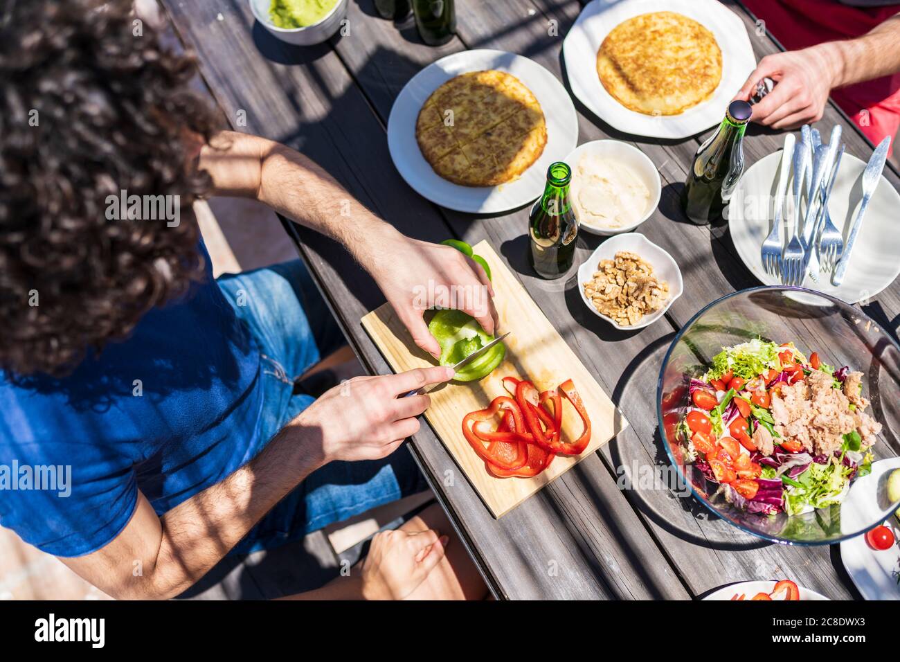 Un jeune homme coupe du poivron à table pendant le brunch Banque D'Images