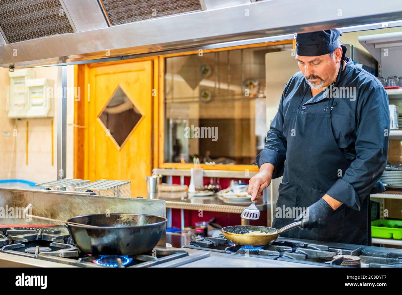Chef avec poêle dans la cuisine espagnole traditionnelle Banque D'Images