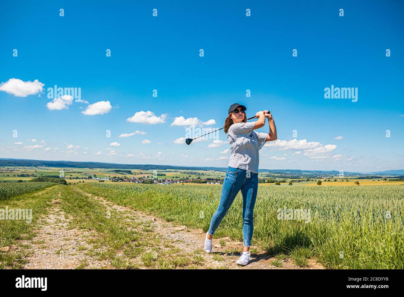 Jeune femme jouant au golf à la campagne Banque D'Images