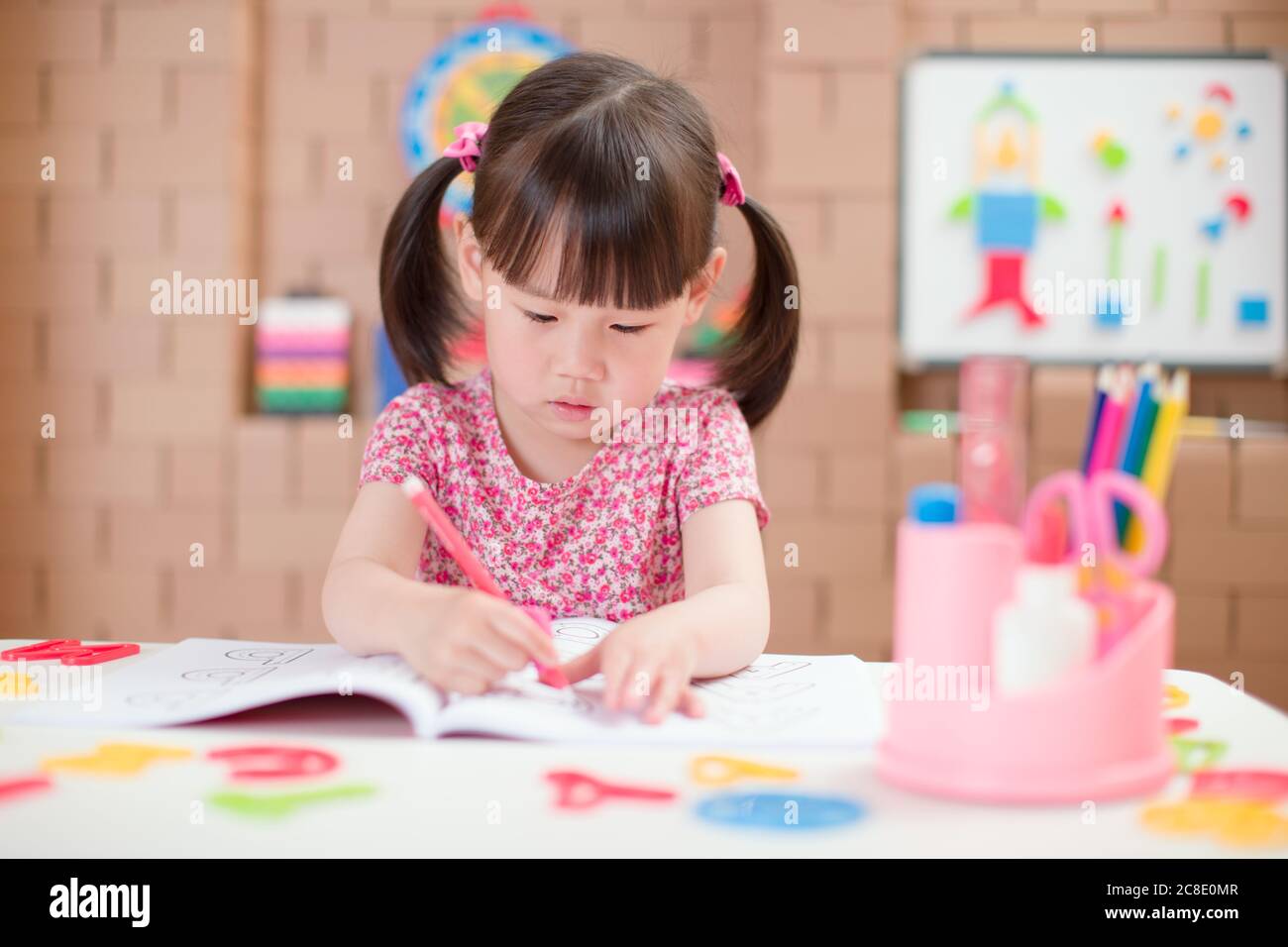 les jeunes filles s'exercent à écrire des lettres pour l'école à domicile Banque D'Images