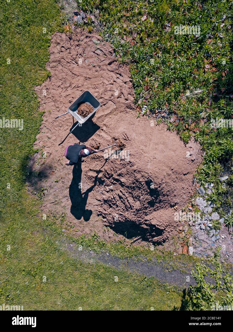 Vue aérienne de l'homme chargé du sable sur la brouette Banque D'Images