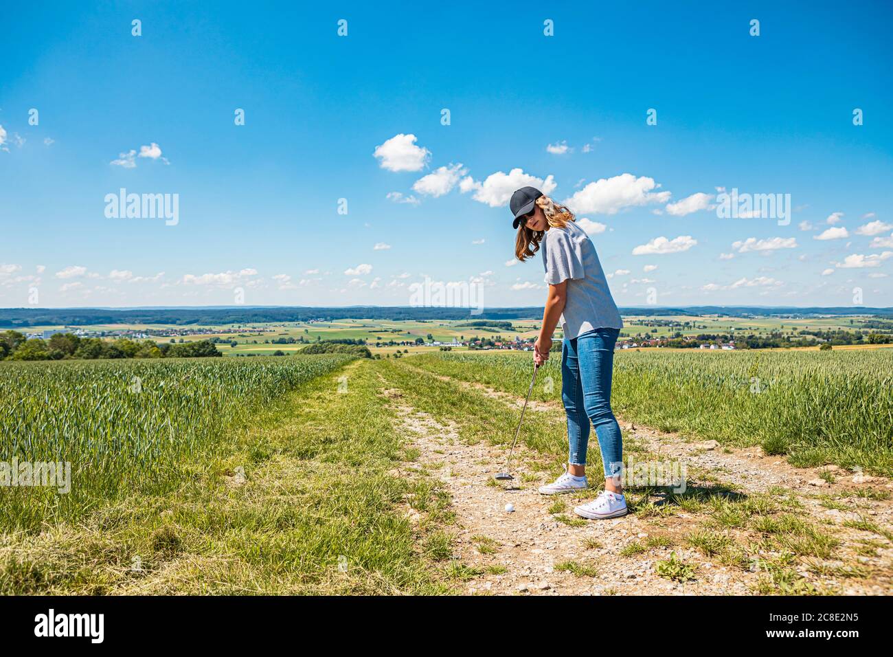 Jeune femme jouant au golf à la campagne Banque D'Images