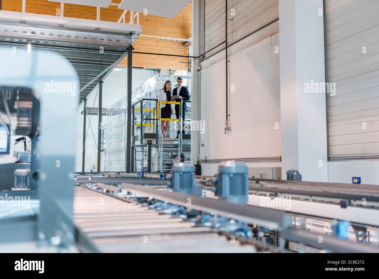 Les gens d'affaires qui examinent la production en usine Banque D'Images