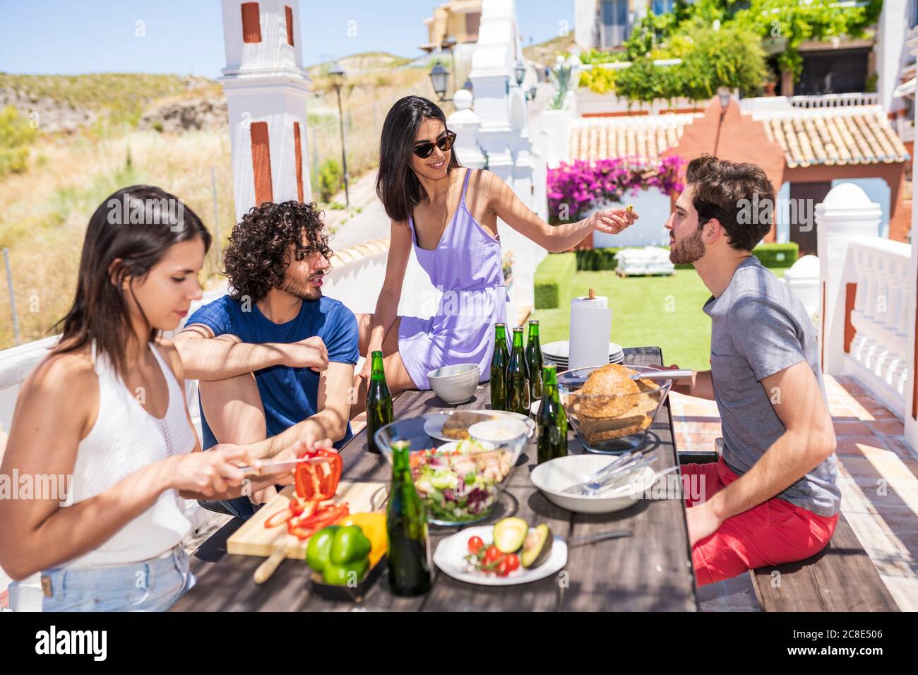 Les jeunes amis multiethniques mangent un brunch sur la terrasse le jour de soleil Banque D'Images