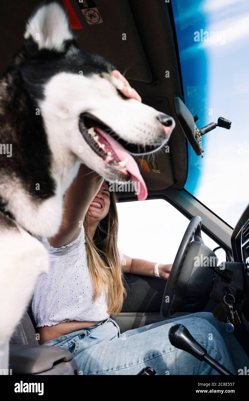 Une femme joyeuse qui a fait le plein d'énergie lorsqu'elle a conduit un véhicule utilitaire sport voyage en voiture Banque D'Images