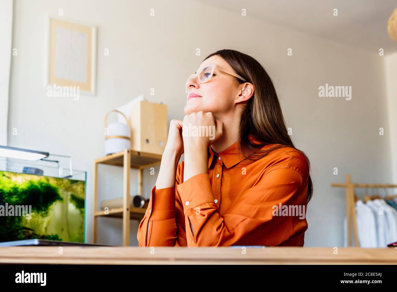 Femme de mode à la maison assis au bureau ayant un pause Banque D'Images