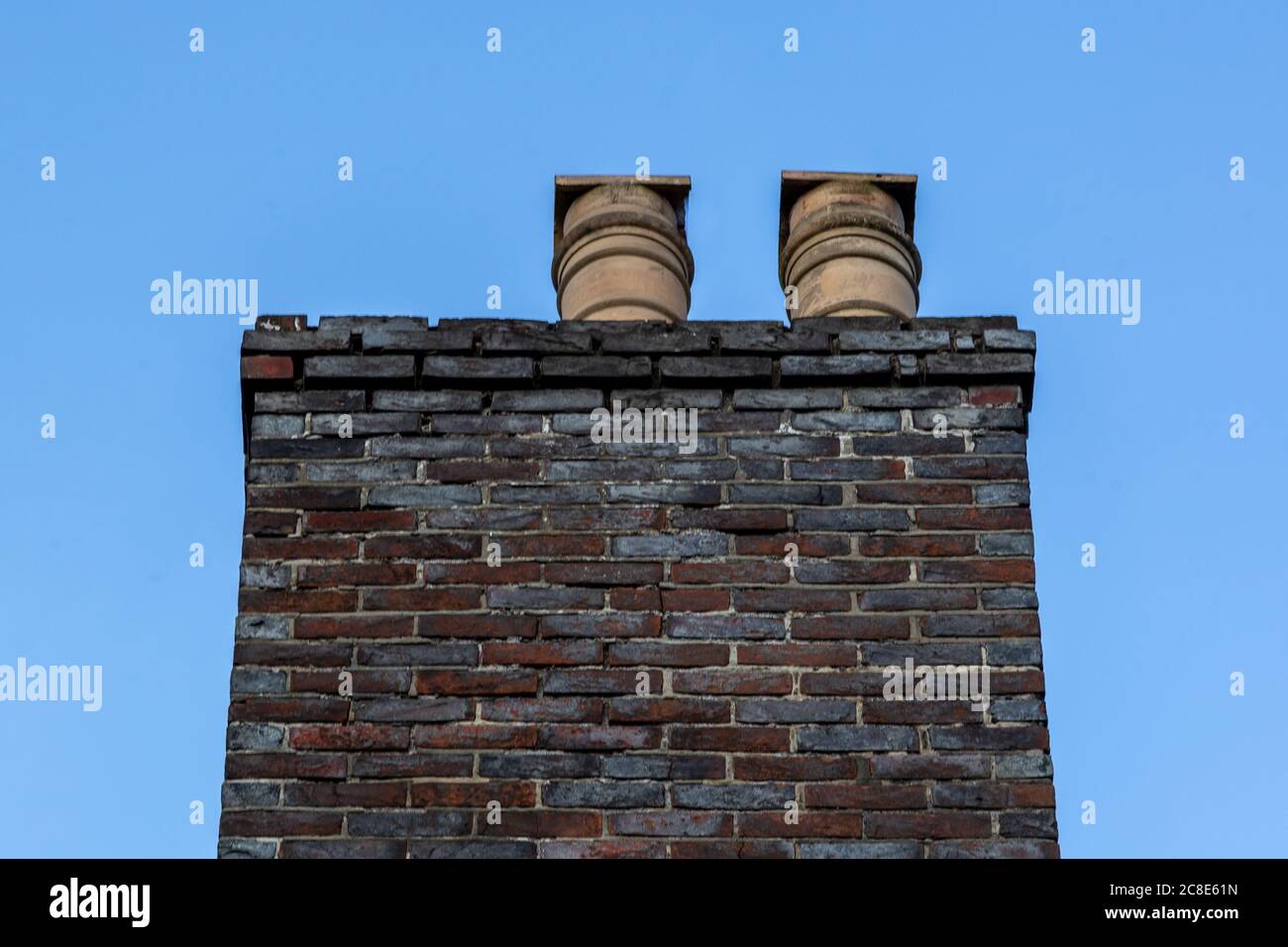 une cheminée en brique avec des pots de cheminée en argile sur le dessus Banque D'Images