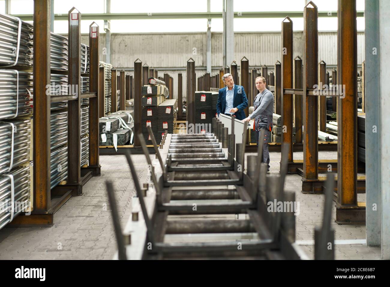 Homme d'affaires parlant à un travailleur dans une usine Banque D'Images