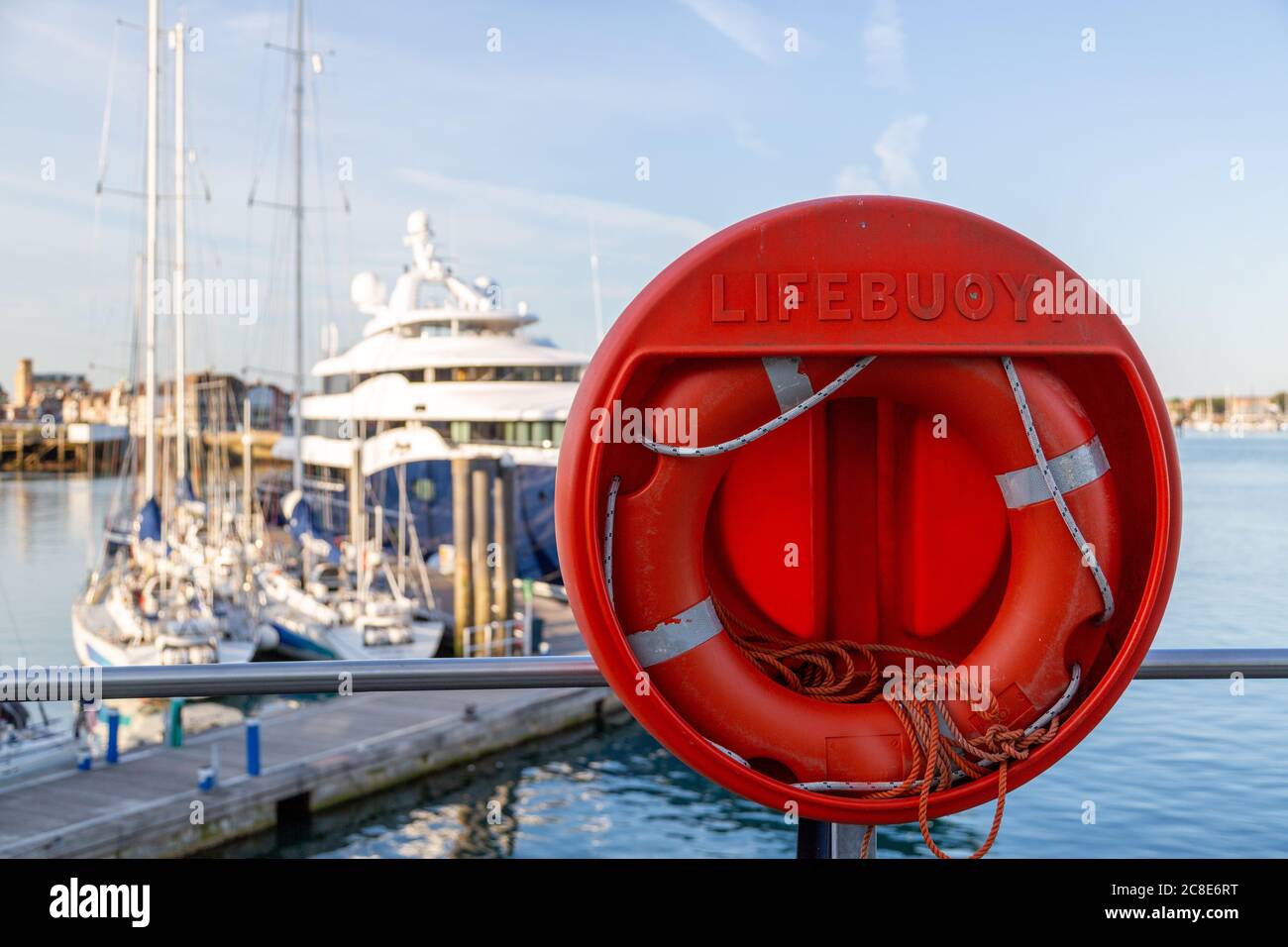 un garçon de vie dans une marina avec des yachts hors foyer en arrière-plan Banque D'Images