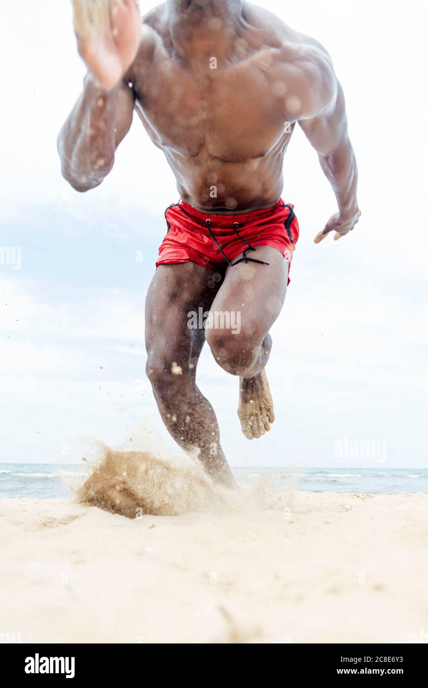 Homme sportif qui court sur la plage Banque D'Images