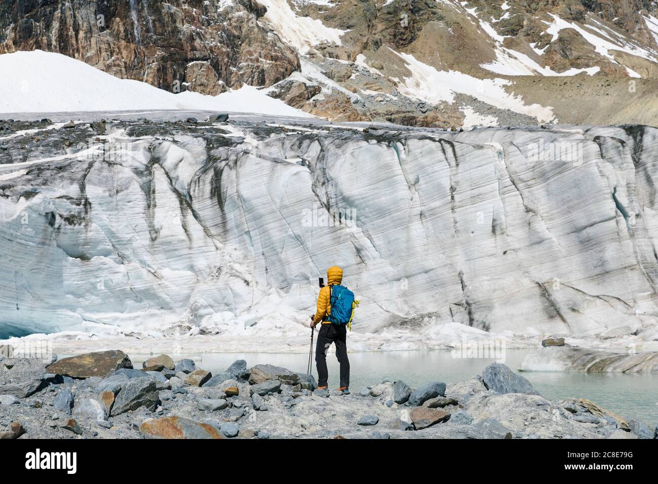 Homme randonnée tout en regardant fondre glacier Banque D'Images