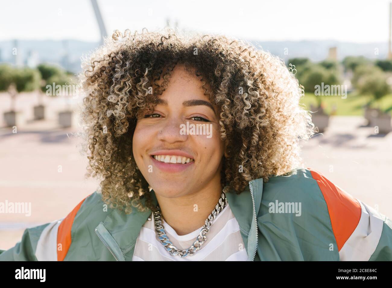 Jeune femme heureuse avec des cheveux en relief pendant la journée ensoleillée Banque D'Images