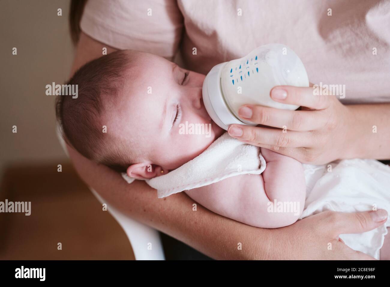 Mère biberon bébé fille à la maison Banque D'Images