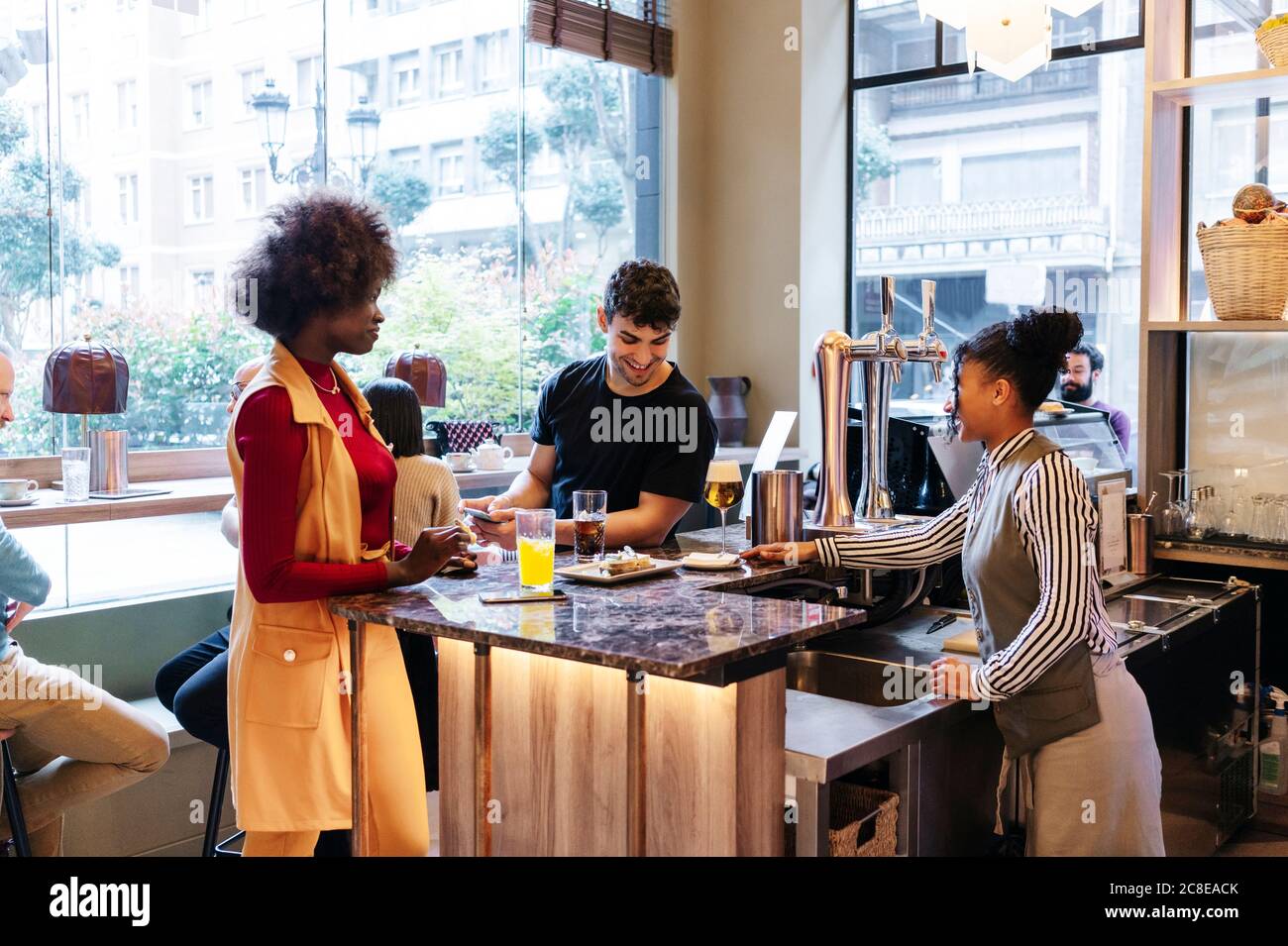 Rendez-vous entre amis dans un restaurant chic, parlant au bar Banque D'Images