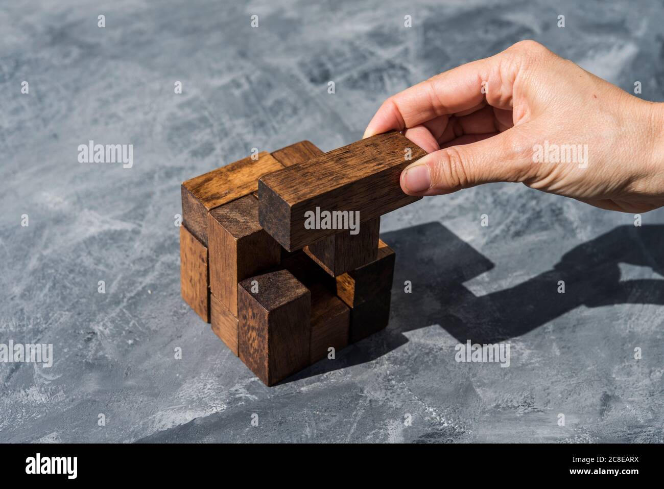 Main de femme assemblant des pièces de puzzle en bois Banque D'Images